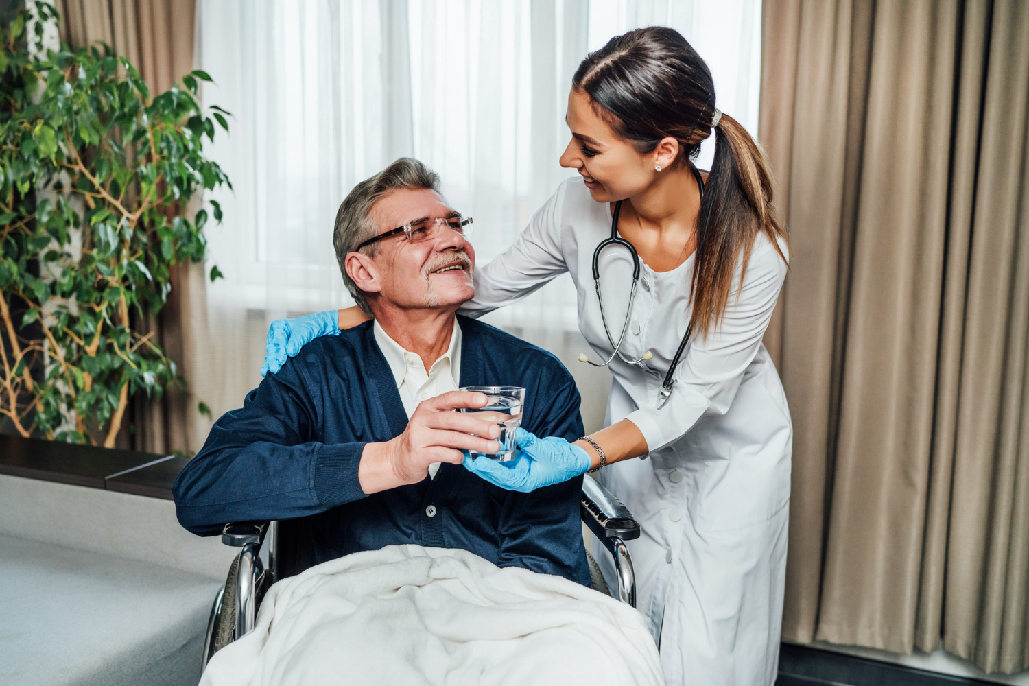 older-man-wheelchair-smiles-nurse-assistant-she-hands-him-glass-water
